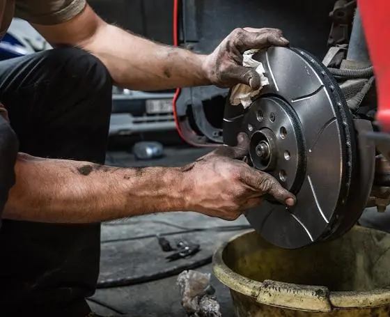 Mechanic holding a brake disc during a brake repair